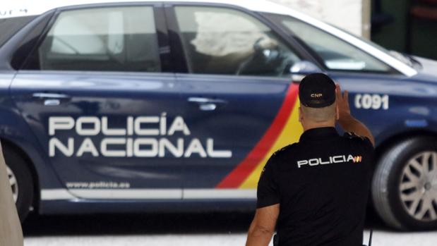Imagen de archivo de un policía junto a un coche patrulla