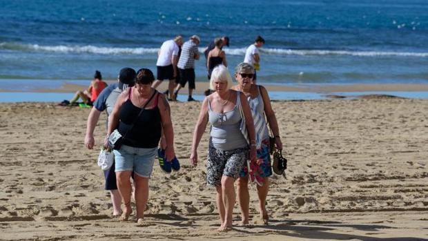Varias turistas británicas caminan por la playa en Benidorm, este viernes