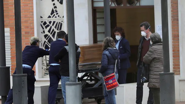 Trabajadores de la funeraria trasladan un cadáver al cementerio de La Almudena