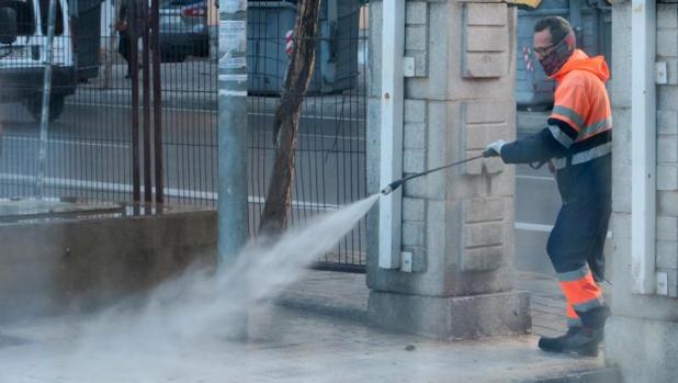 Un empleado de limpieza desinfecta un acceso al Hospital General de Alicante, este miércoles