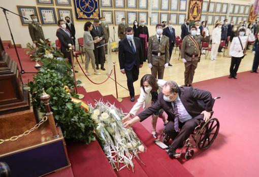 The minister helps lay flowers to one of the relatives of the deceased