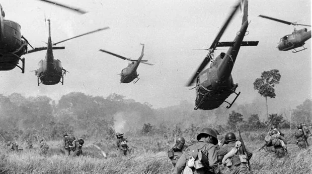 Helicópteros del ejército de EE. UU. Lanzan fuego de ametralladora contra una línea de árboles para cubrir el avance de las tropas terrestres del sur de Vietnam en un ataque contra un campamento del Vietcong