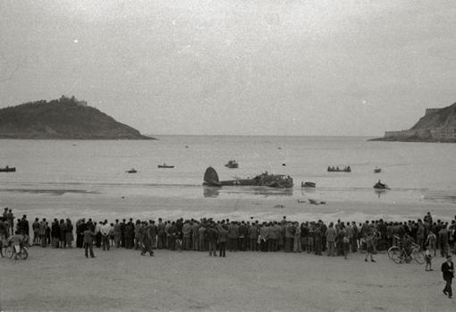 Avión de Degrelle, tras estrellarse en La Concha, con cientos de vecinos de San Sebastián observando la escena