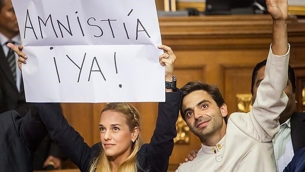 Lilian Tintori, esposa del líder opositor detenido Leopoldo López, acompañada de diputados de la Mesa de Unidad Democrática, sostiene un cartel pidiendo una amnistía