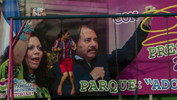 Una niña juega frente al cartel electoral a favor del candidato a la reeleción Daniel Ortega, y la aspirante a vicepresidenta, Rosario Murillo