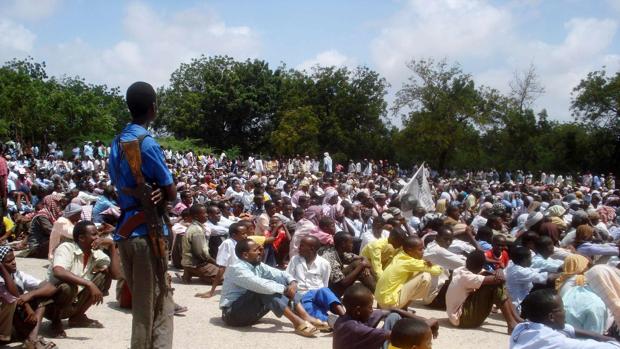 Un soldado armado de Al Shabab vigila a una gran audiencia de somalíes en la capital, Mogadiscio