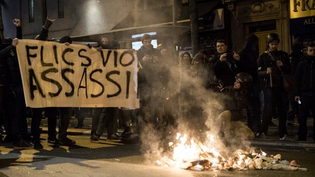 Varias personas sostienen una pancarta en la que se puede leer «Policías, violadores, asesinos» durante una manifestación en solidaridad con Théo y contra la violencia policial en París
