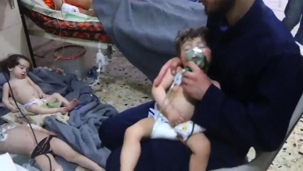 Un voluntario sostiene la máscara de oxígeno a un niño, este domingo en un hospital de Duma, tras el ataque con armas químicas