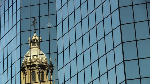Vista de una de la cúpulas de la catedral de Santiago reflejada en un edificio