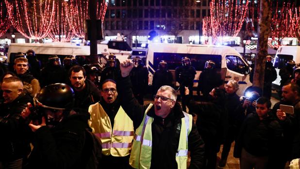 Los manifestantes antigubernamentales "chaleco amarillo" (gilets jaunes) protestan en los Campos Elíseos en el centro de París