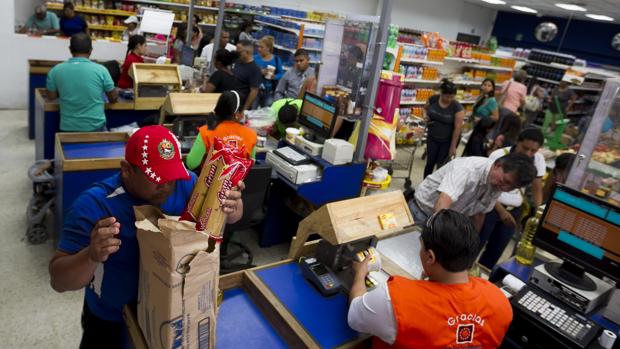 Un grupo de personas hacen las compras dentro de un supermercado en Caracas