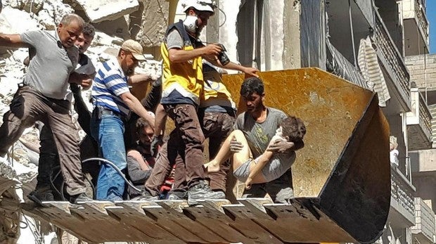 Un grupo de personas intenta rescatar a un niño entre las ruinas de una de las ciudades de Idlib