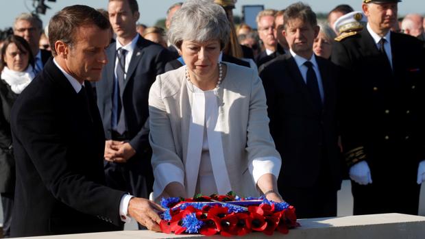 Emmanuel Macron y Theresa May realizan una ofrenda floral durante la colocación de la primera piedra de un monumento británico