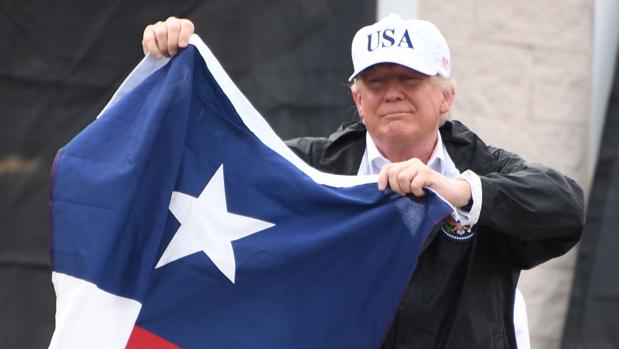 Donald Trump posa con una bandera de Texas, en 2017