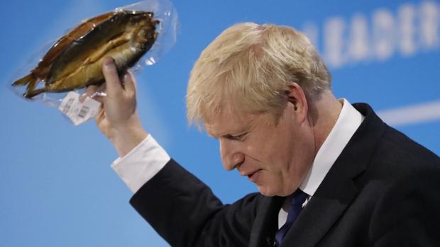 Boris Johnson muestra un arenque empaquetado este miércoles en un acto de la carrera por el liderazgo conservador