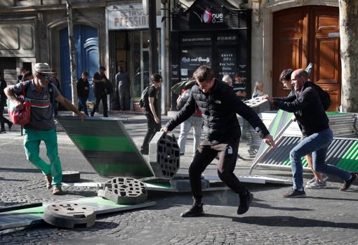 Un grupo de manifestantes intenta levantar una barricada en París
