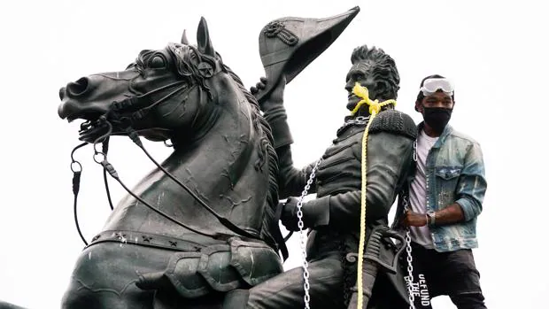 Un manifestante rodea con cadenas y cuerdas la estatua de Andrew Jackson en Washington para intentar derribarla