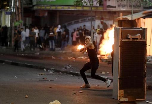 A young Palestinian prepares to throw a Molotov cocktail in Hebron (West Bank)