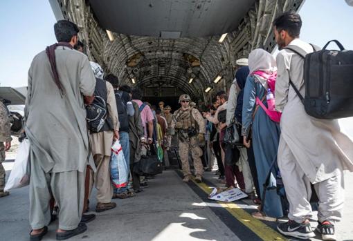 Decenas de personas embarcan en un avión de la fuerza aérea de EE.UU. en el aeropuerto internacional Hamid Karzai de Kabul