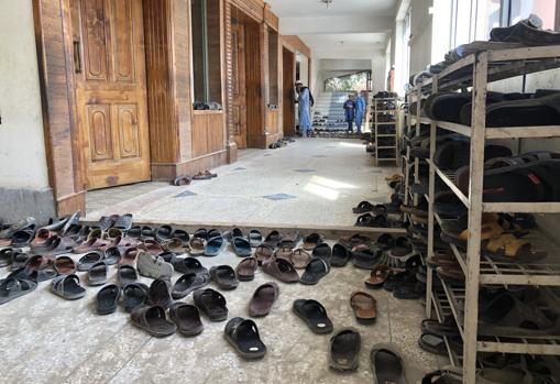 Lots of sandals at the entrance of a crowded class