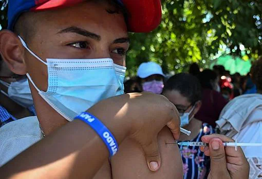 Un sanitario hondureña aplica la vacuna de Moderna a un joven nicaragüense