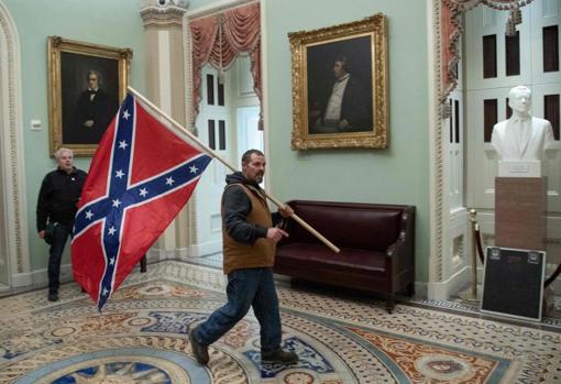 A man with a Confederate flag, in the halls of the Capitol during the assault
