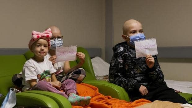 Los pacientes se sientan en sillas trasladadas a los pasillos en el sótano del hospital infantil Okhmadyt en Kiev, Ucrania