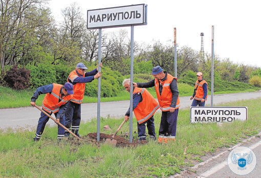 Empleados públicos cambian los carteles ucranianos por los rusos a las afueras de Mariúpol