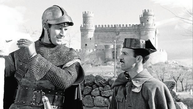 Charlton Heston conversa con un guardia civil durante el rodaje de «El Cid» en Madrid, en 1961, con el castillo de Manzanares el Real al fondo