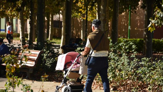 Un hombre mayor pasea un carrito de bebé