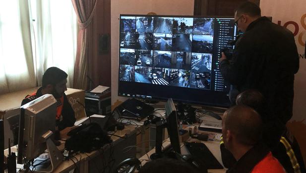 Unos operarios vigilan la zona de control de cámaras del Centro de Coordinación Operativa (CECOP) que coordina todo el dispositivo de seguridad de la Semana Santa de Sevilla