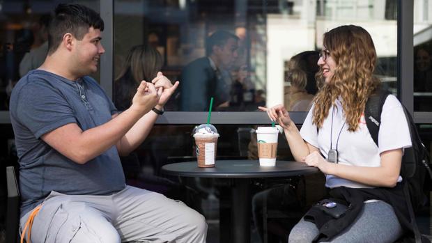 Dos jóvenes se expresan mediante lengua de signos en el local de Washington