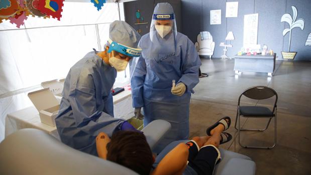 Los miembros de Spedali Civili realizan hisopos nasales y pruebas de coronavirus en la ubicación de prueba en Palazzetto della Fiera en Brescia, Italia