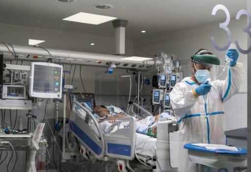 Un sanitario prepara la medicación en un box de la UCI