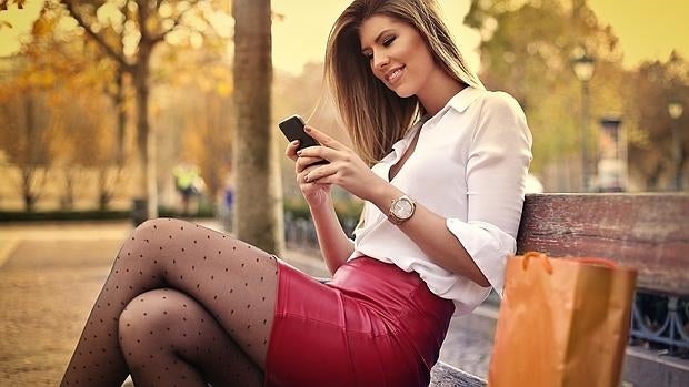 Una mujer consulta su teléfono móvil inteligente