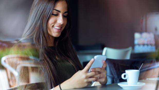 Una joven consulta su teléfono móvil inteligente