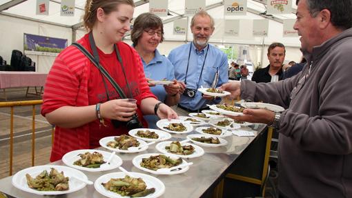 Varias personas se disponen a degustar una menestra en una de las edición de las Jornadas de Exaltación de la Verdura, en Tudela